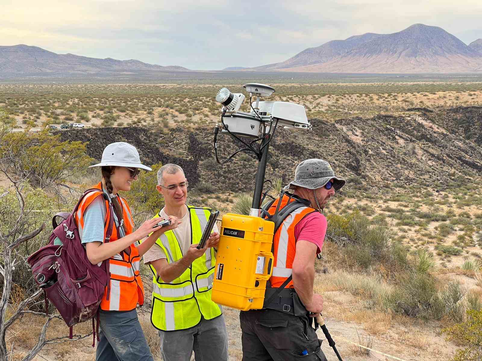 Forscher befestigen eine Lidar-Einheit am Rücken eines anderen in der Wüste.