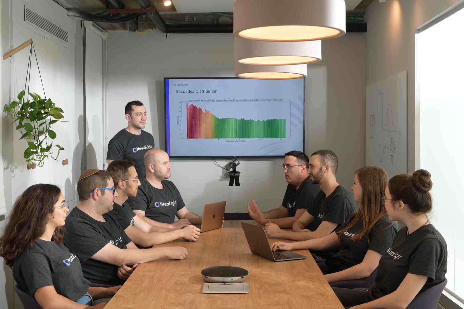 Ein Meeting in einem Büro, das digitale Lesungen des Gesichts eines Presons zeigt.