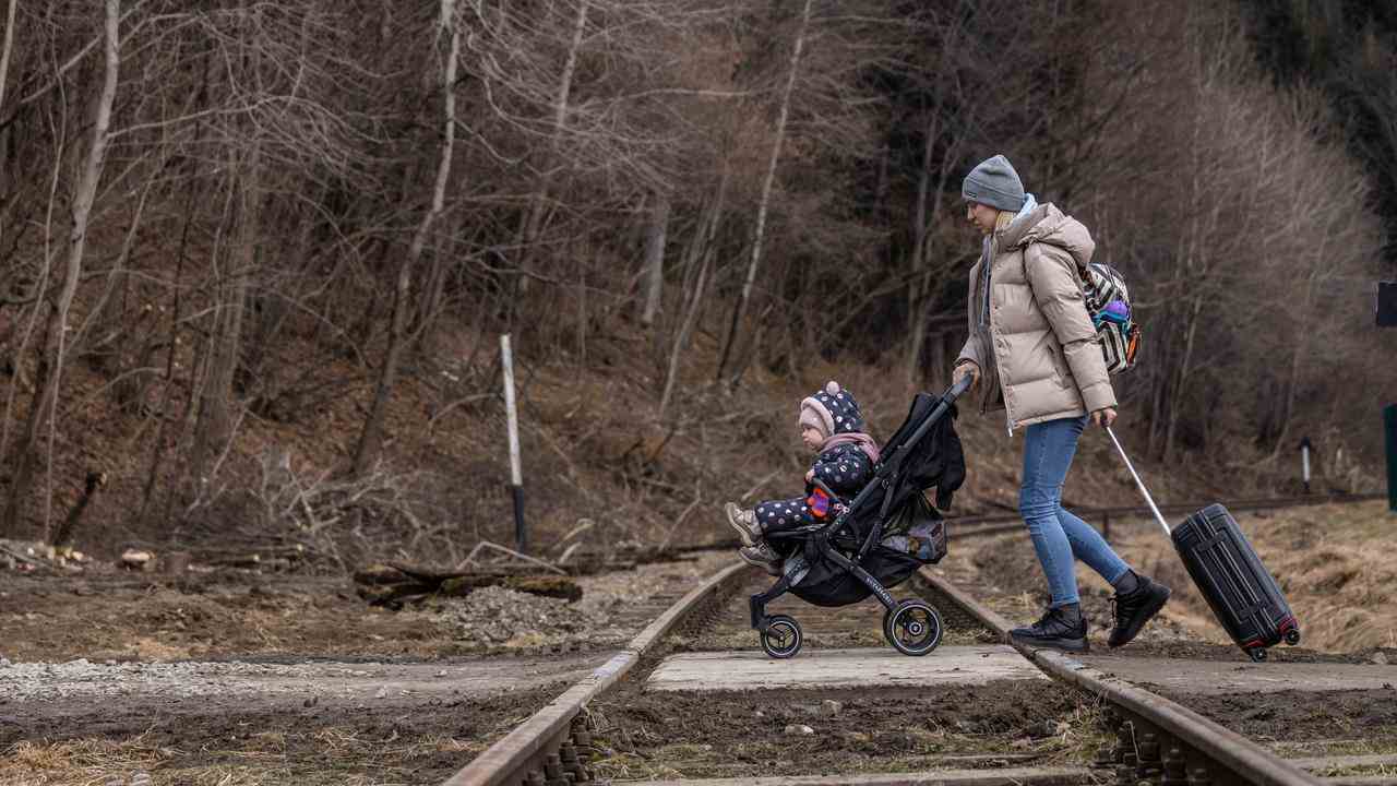 Ein ukrainischer Flüchtling überquert mit seinem Kind die Grenze nach Polen.