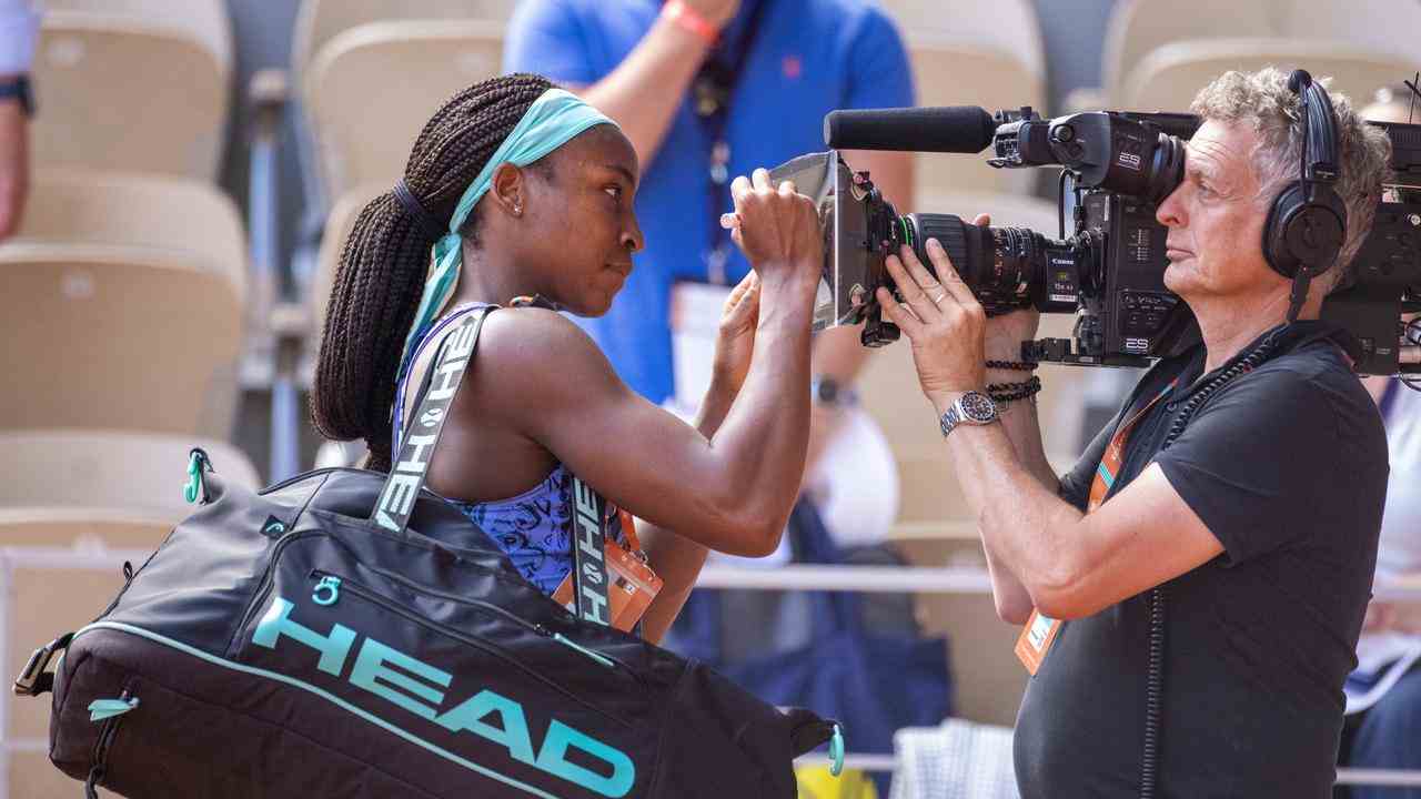 Coco Gauff schreibt den Text „Frieden, Waffengewalt beenden“ auf die Kameralinse.