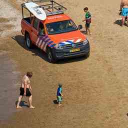 Rettungsdienste entfernen Mann aus dem Meer der die rote Flagge