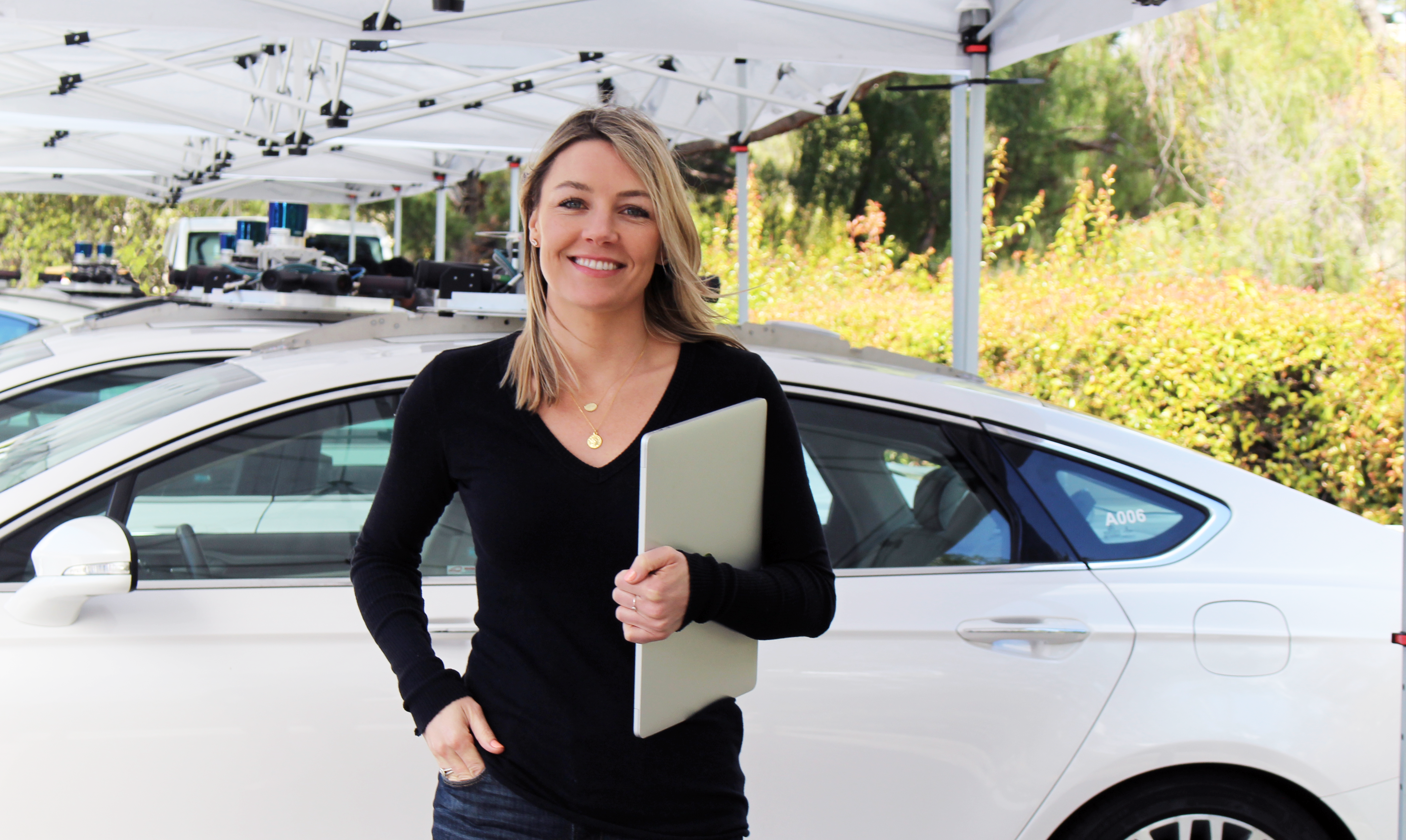 Frau mit Klemmbrett vor Auto