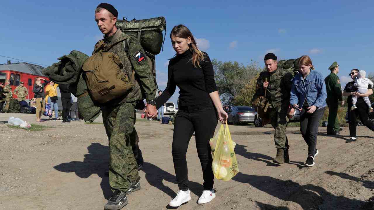 Russische Rekruten gehen Hand in Hand mit ihren Frauen.