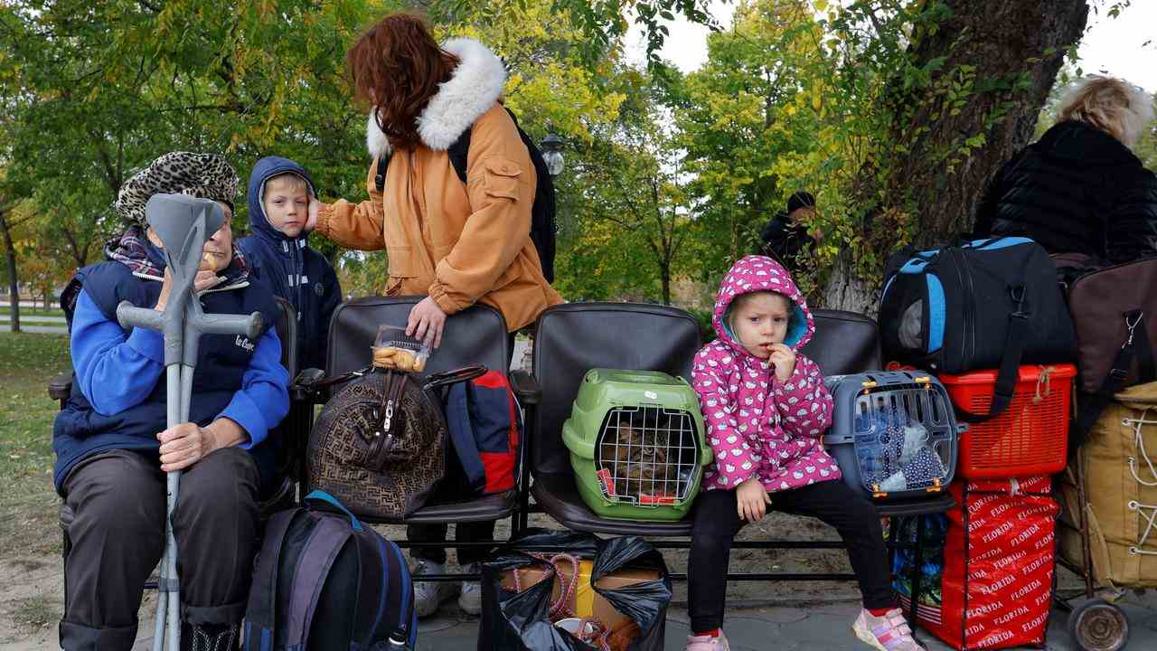 Kinder warten auf den Bus, der sie abholt, um Cherson zu verlassen.