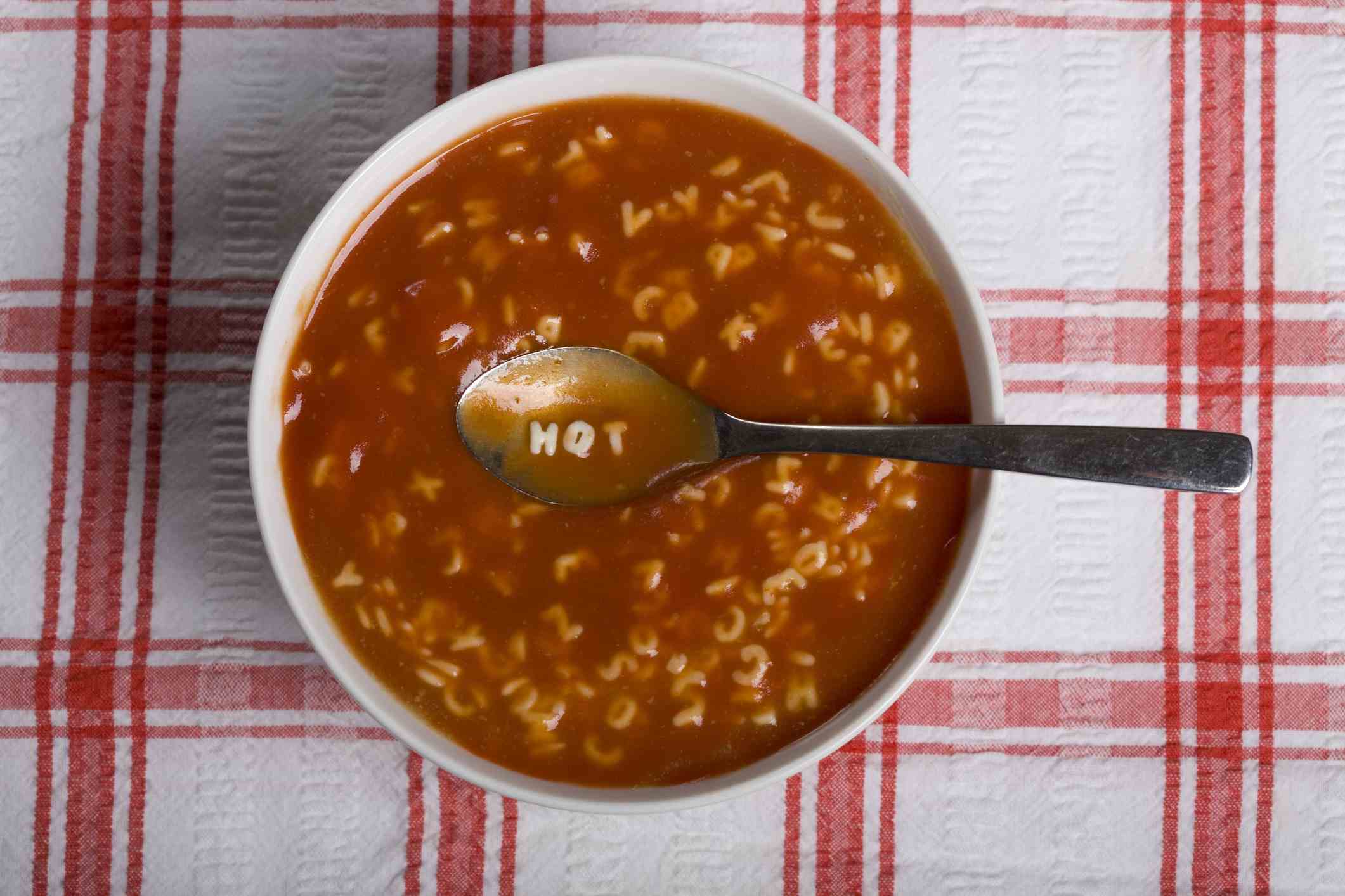 Buchstabensuppe mit dem Wort heiß auf dem Löffel