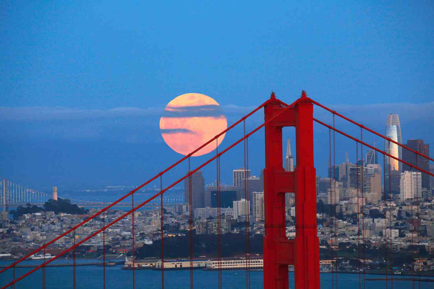 Berühmte Golden Gate Bridge mit Gebäuden im Hintergrund in San Francisco, Kalifornien, USA