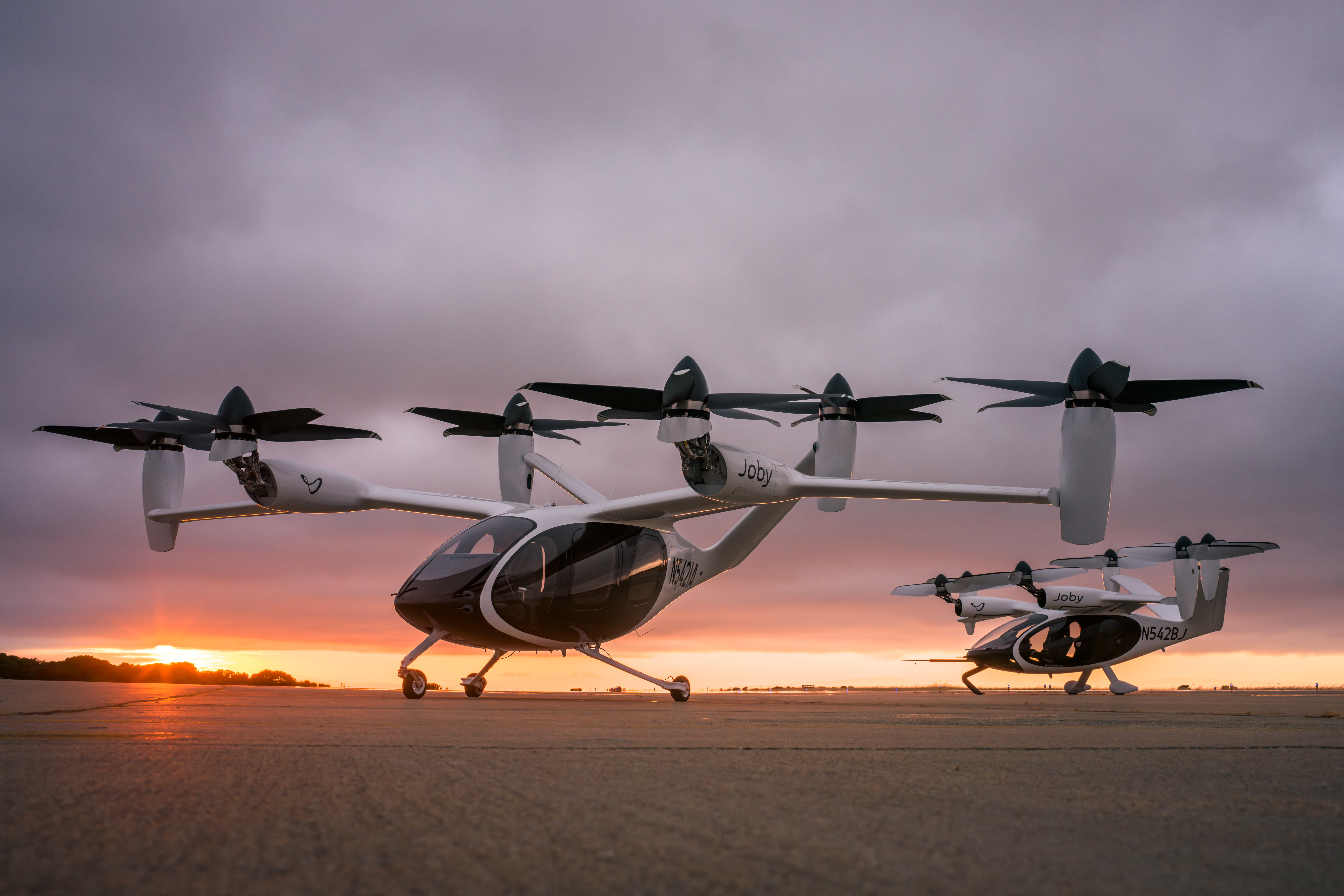 zwei arbeitsreiche Luftfahrtflugzeuge vor einem Sonnenuntergang