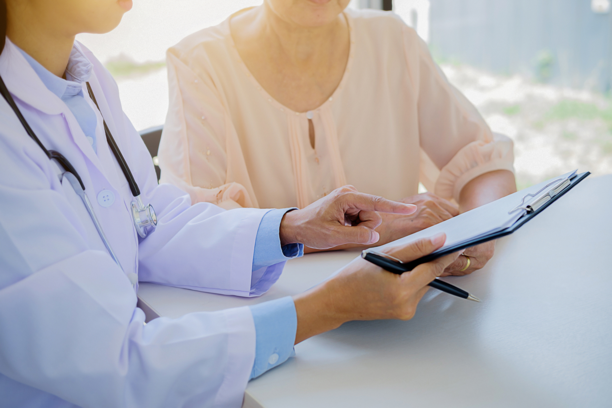 Ärztin zeigt dem Patienten im Krankenhaus die Zwischenablage