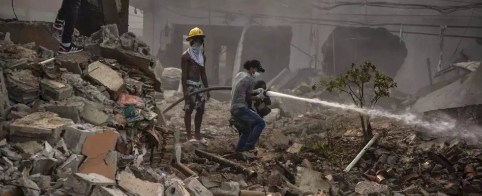 Dominikanische Feuerwehrleute finden weitere Leichen waehrend sie die Flammen der