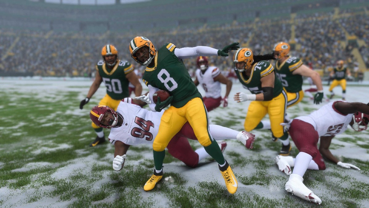 Ein Foto eines Spielers der Green Bay Packers, der im Schnee einen Spieler der Washington Commanders aus dem Spiel wirft, in einem Artikel über das Spiel