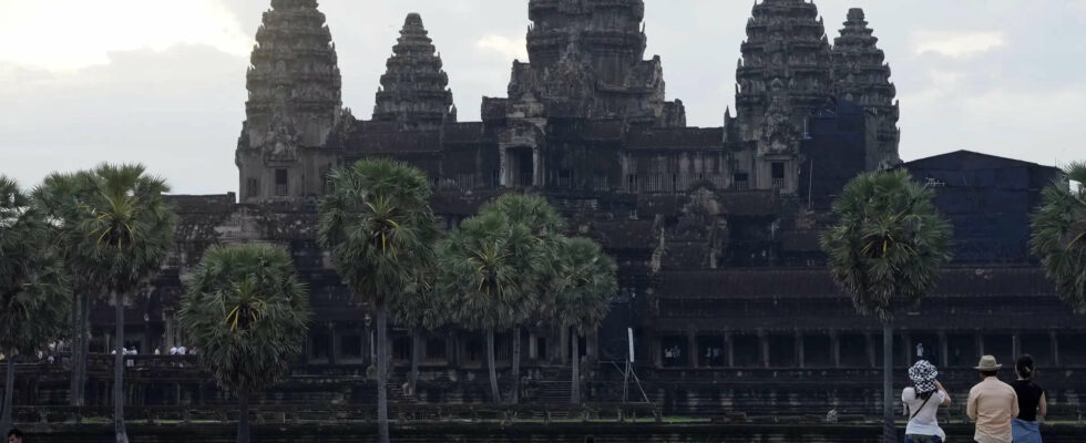 Touristen trampeln durch Angkor Wat und imitieren das Spiel „Temple