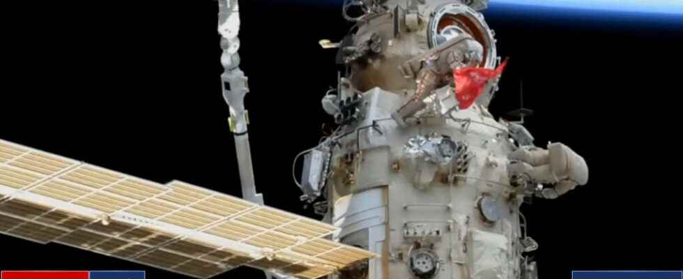 Two Russian cosmonauts unfurl a Soviet flag during an exit