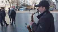 The saxophonist created a warm atmosphere on the pedestrian street