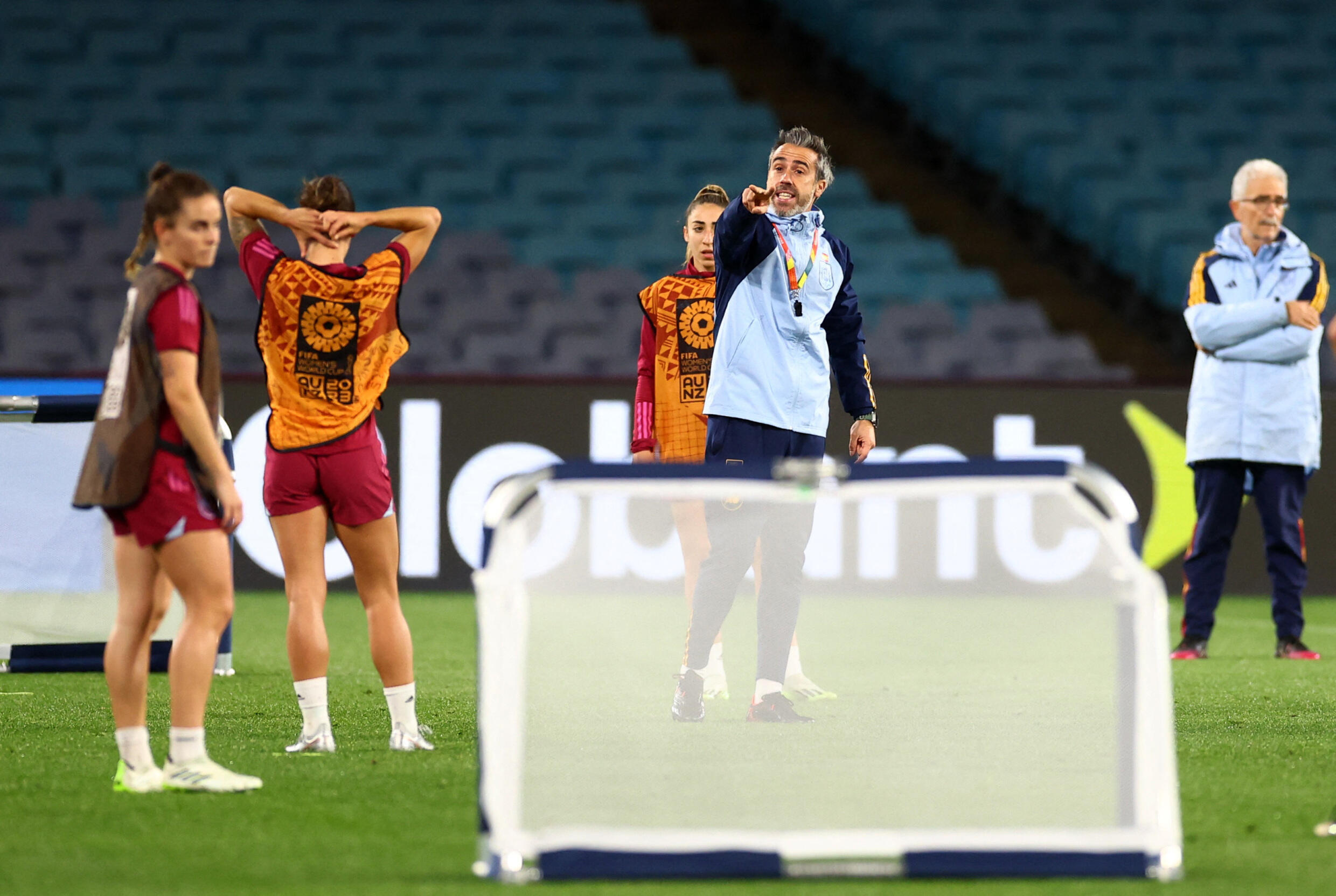 Jorge Vilda (in blue, center), gives instructions during a training session with the Spanish team during the World Cup.