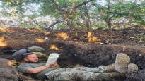 A Ukrainian special forces soldier reads even in a trench