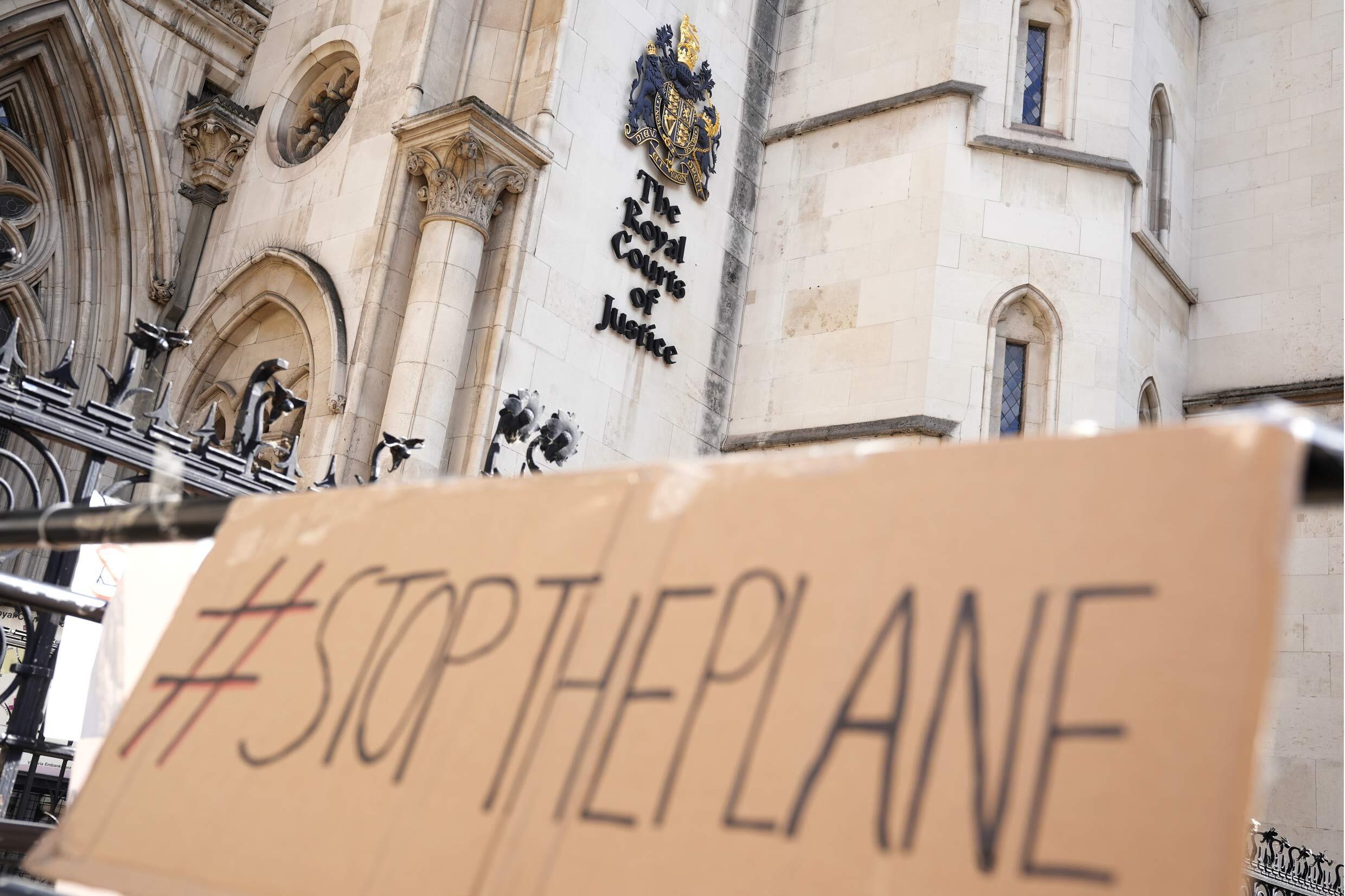 A sign left outside the High Court where the decision on Rwanda deportation flights is taking place, in London, Monday June 13, 2022.