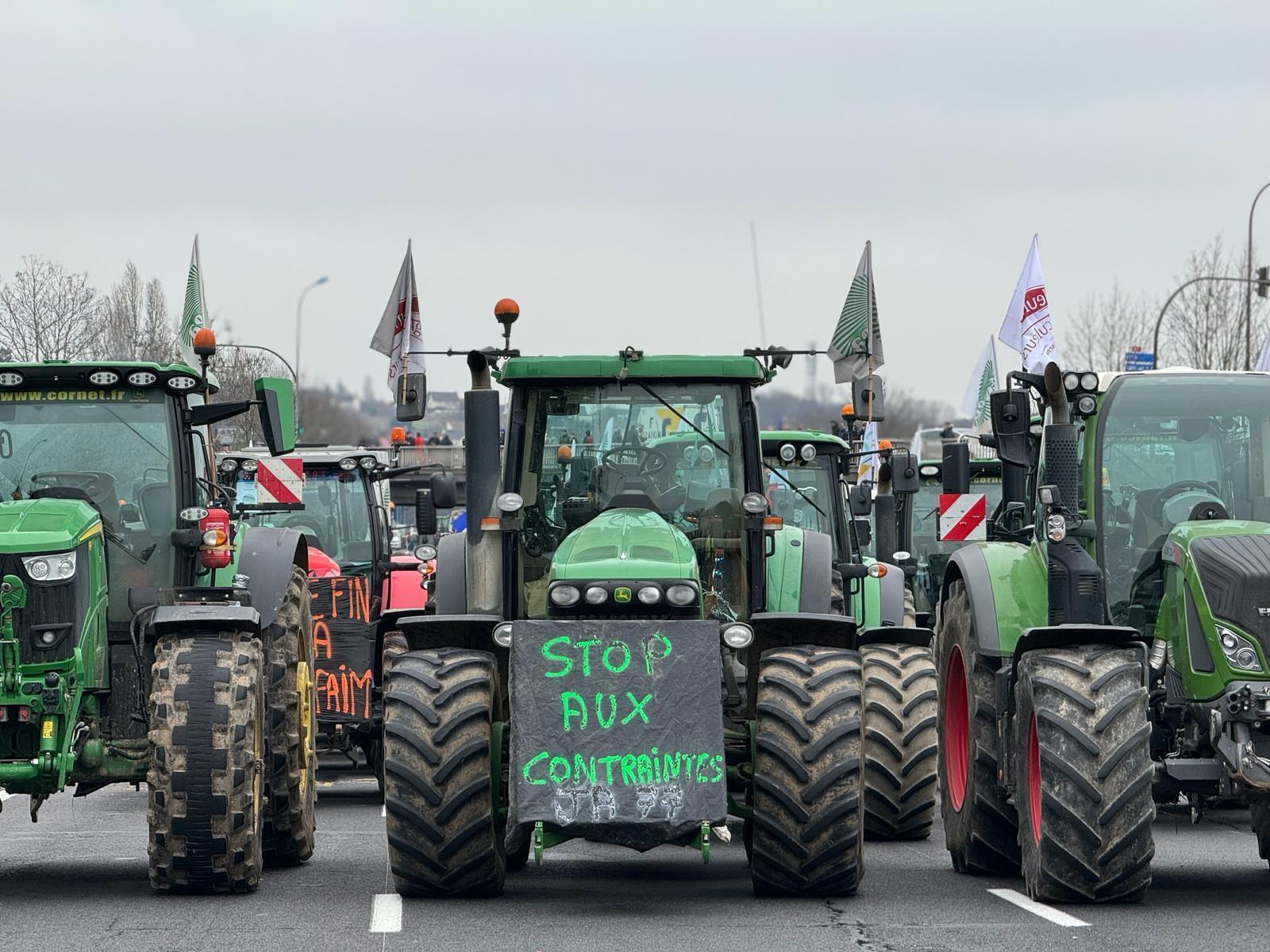 Signs are hung on agricultural machinery.  For example, we can read “stop the constraints”.