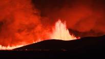 Lava from a volcano flows towards a fishing village in