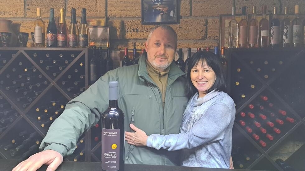 Maryan and Natalya Shevchenko in their cellar with a bottle of the wine they created.