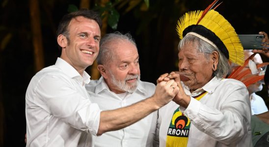 Raoni and his son Emmanuel Macron kiss in a ceremony