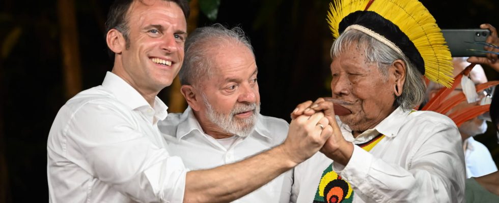 Raoni and his son Emmanuel Macron kiss in a ceremony