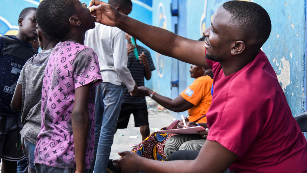 A man administers the cholera vaccine to a Zambian girl, in Lusaka, January 17, 2024.