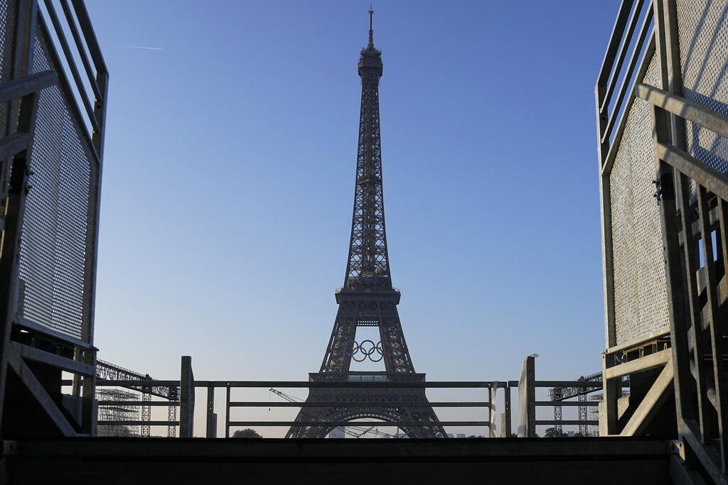 The five Olympic rings hanging from the Eiffel Tower, seen from the Trocadéro.