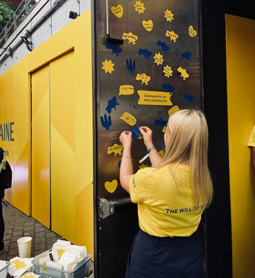 Volunteers and supporters write messages of hope on the door of the Ukrainian Olympic House, July 27, 2024.