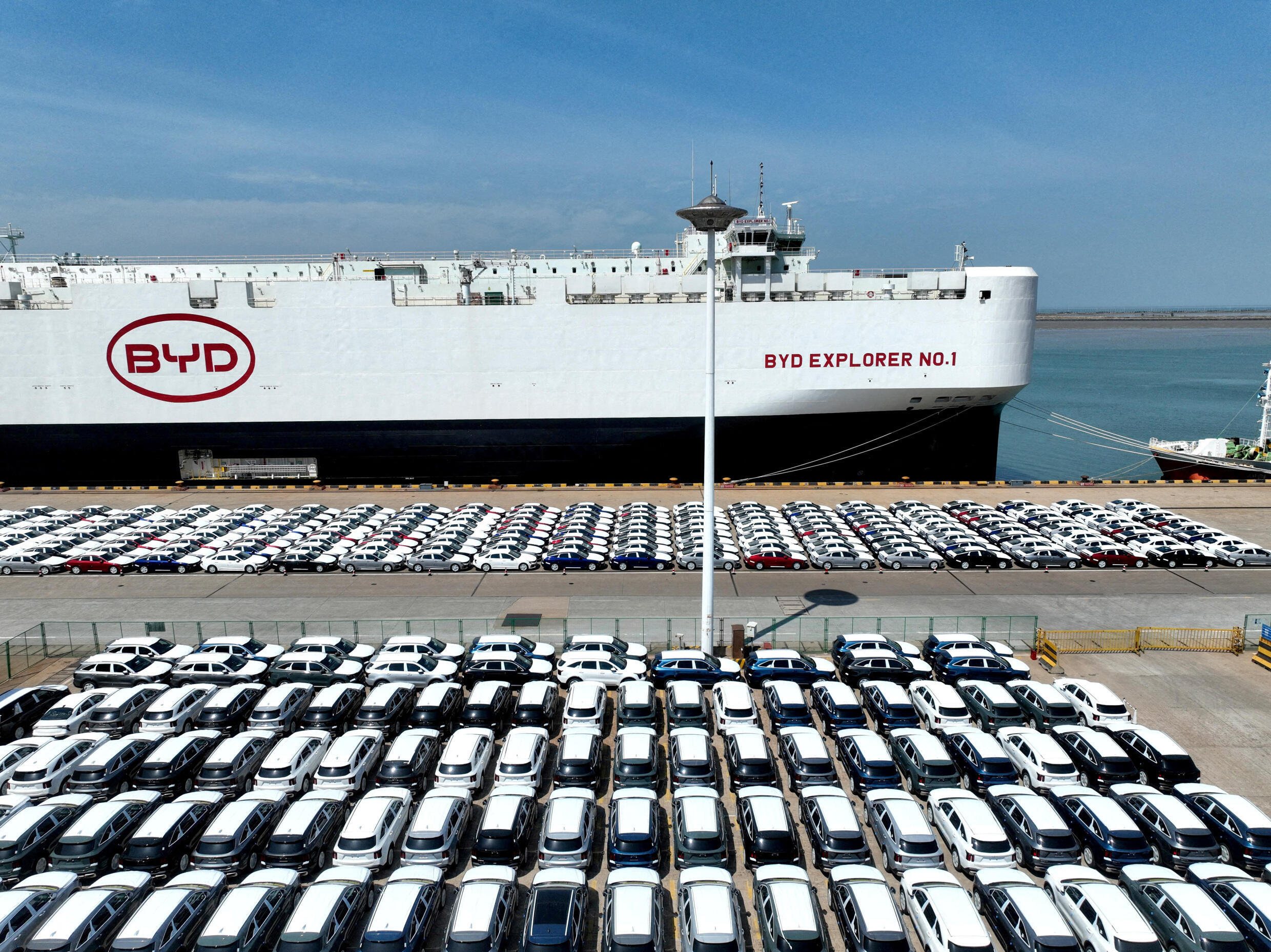 A drone view shows BYD electric vehicles before being loaded onto the rolling stock carrier 