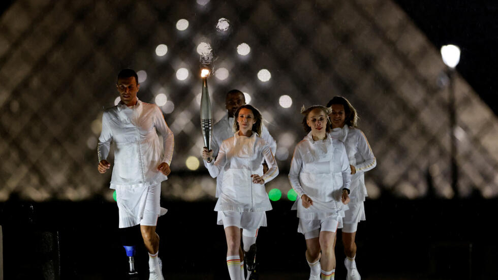 Paris 2024 Olympic Games - Opening Ceremony on 26 July 2024. The Olympic flame is held by the President of the French Paralympic Committee Marie-Amélie Le Fur at the Louvre Museum during the Opening Ceremony. Paris hosts the Paralympic events from 28 August to 8 September 2024.