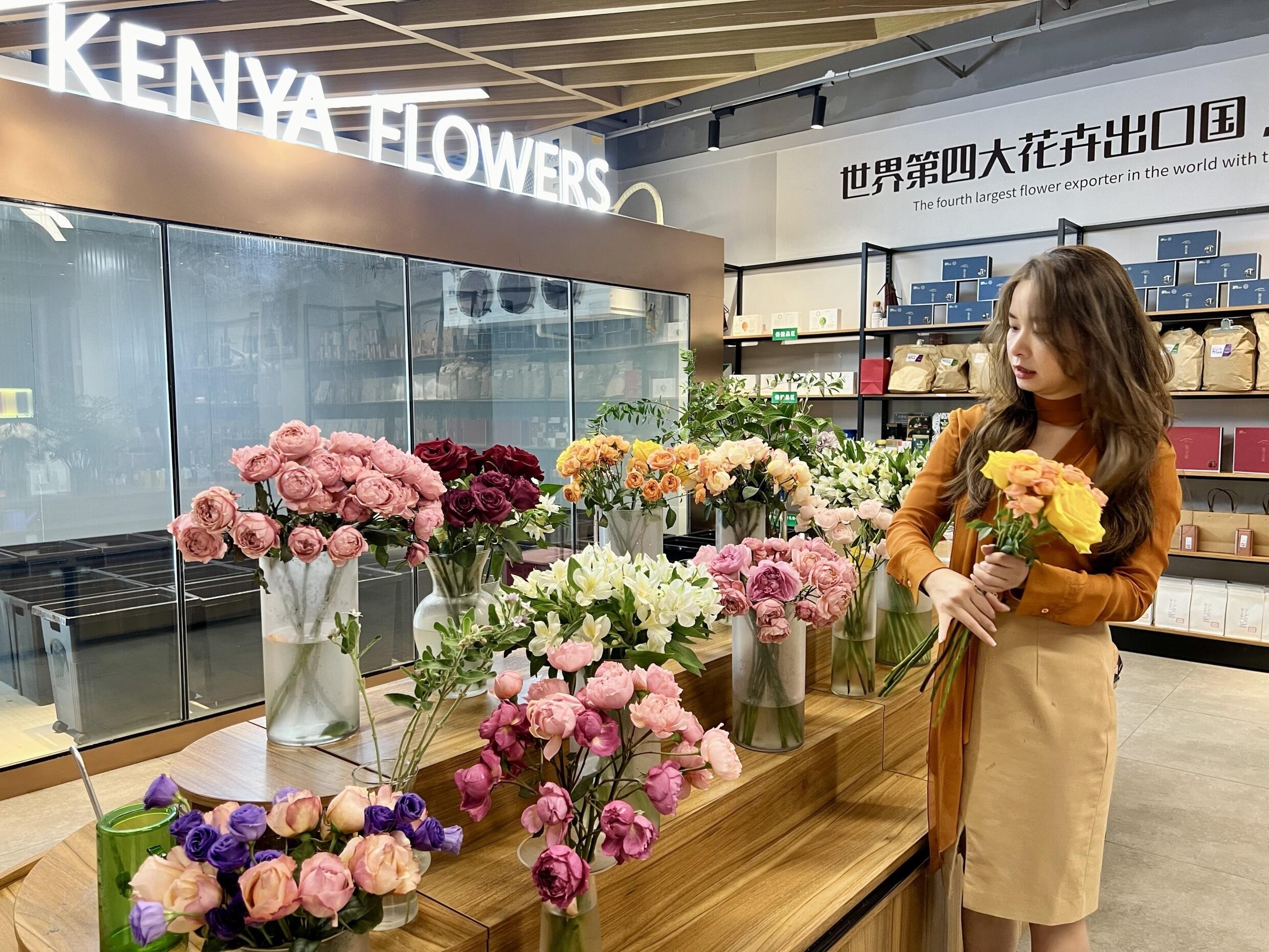 Huang Zinan, director of Xiyue Flowers, arranges bouquets of roses imported from Kenya.