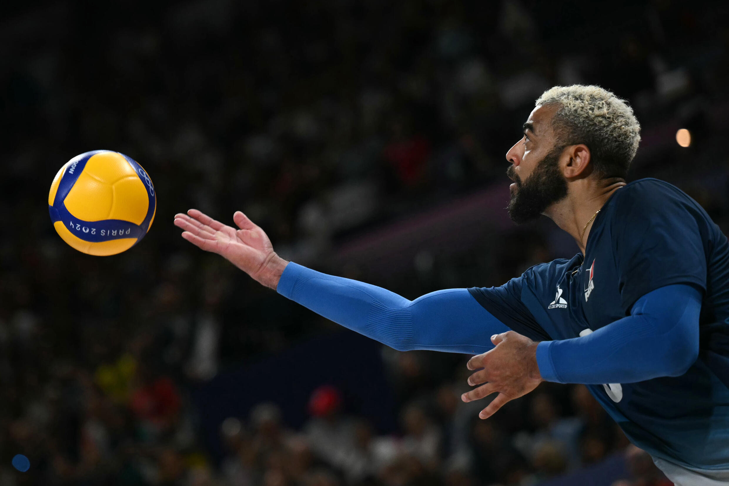 Earvin Ngapeth, serving under the eyes of the French team, on August 10, 2024, during the Olympic volleyball tournament in Paris